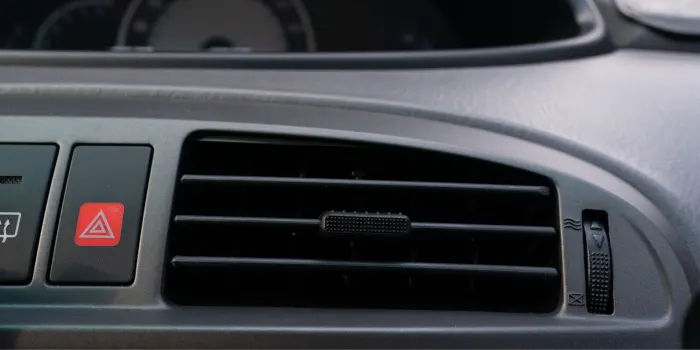 A close-up view of a car's dash board & air conditioner vent